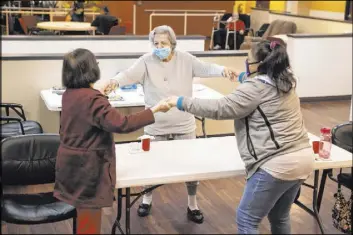  ??  ?? Easter Vito, 84, from left, Grace Fagone, 83, and Lani Reardon, 61, dance to music March 2 during a physical activity at the Nevada Adult Daycare Health Center.