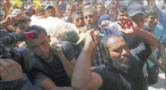  ?? (Photo: AP) ?? GAZA CITY — Mourners chant Islamic slogans while carrying the body of Ahamd Omar, 20, during his funeral in the Shati refugee camp, yesterday. Omar was killed Tuesday during a protest at the entrance of Erez border crossing between Gaza and Israel.