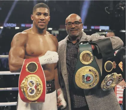  ??  ?? 2 Anthony Joshua displays his belts alongside his father, Robert Joshua, following his tenth-round stoppage of Carlos Takam in Cardiff on Saturday night.