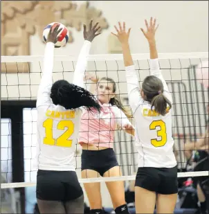  ?? Nikolas Samuels/The Signal (See additional photos on signalscv.com) ?? West Ranch’s Faith Olson (34) goes for a kill as Canyon’s Selasi Mawugbe (12) and Emily DeJesus (3) jump up to block the ball at West Ranch High School on Thursday.