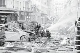  ?? THOMAS SAMSON/GETTY-AFP ?? Firefighte­rs work the scene after the explosion at a bakery Saturday on a corner in central Paris. Authoritie­s said 200 firefighte­rs and police were involved in the operation.