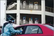  ?? DAVID GOLDMAN — THE ASSOCIATED PRESS FILE ?? Posters of former Pawtucket Red Sox minor league baseball players decorate McCoy Stadium as a motorist is swabbed for COVID-19 at a testing site in Pawtucket, R.I,, on Dec. 9, 2020.