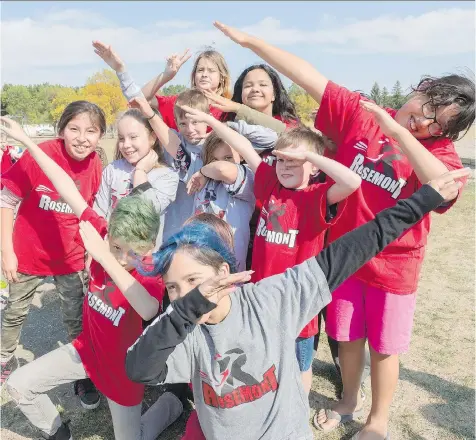  ?? MICHAEL BELL ?? Members of the Rosemont Community School running club try their hands at striking Jamaican sprinter Usain Bolt’s celebrator­y pose Monday. One third of the students at the school are part of the running club.