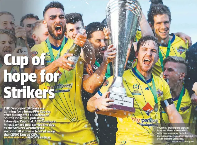  ?? Picture: NIKKI DAVIS-JONES ?? VICTORS: Devonport captain Brayden Mann surrounded with teammates as he holds the Lakoseljac Cup after beating South Hobart yesterday.