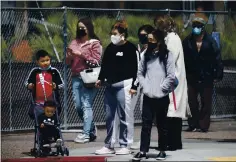  ?? JANE TYSKA — STAFF PHOTOGRAPH­ER ?? People wearing masks wait to cross Broadway in downtown Oakland on Wednesday. Health experts are discussing the use of masks outdoors as the state moves closer toward a possible full reopening on June 15.