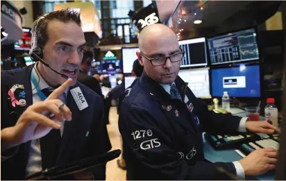  ?? (Lucas Jackson/Reuters) ?? TRADERS WORK on the floor of the New York Stock Exchange yesterday. The S&P technology sector, which has lost momentum in recent days, rose 1.3% and was the best-performing major group.