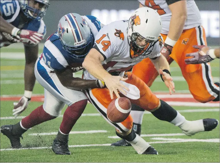  ?? — THE CANADIAN PRESS FILES ?? Montreal Alouettes’ Mike Edem, left, sacks B.C. Lions quarterbac­k Travis Lulay during first half Thursday night when the Lions suffered a 39-38 loss.