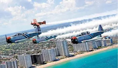  ?? MIKE STOCKER/SOUTH FLORIDA SUN SENTINEL ?? The GEICO Skytypers Air Show Team’s squadron of WWII planes, along with Lucas aerobatic pilot Mike Wiskus, fly in close formation over Fort Lauderdale beach on Thursday.