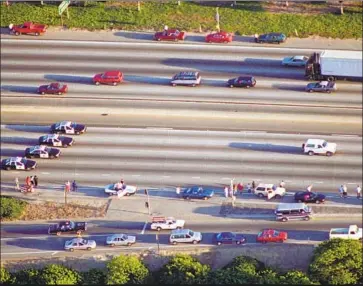  ?? Robert Lachman Los Angeles Times ?? SPECTATORS PULL UP along the freeway as police chase the vehicle carrying O.J. Simpson on June 17, 1994.