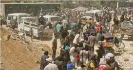  ?? – SANA/Handout via Reuters ?? EVACUATION: People gather before being evacuated from the besieged Damascus suburb of Daraya on Friday.