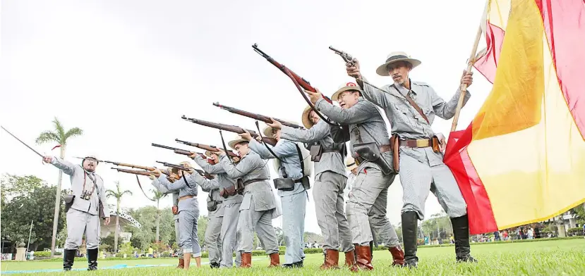  ?? PHOTOGRAPH BY JOEY SANCHEZ MENDOZA FOR THE DAILY TRIBUNE@tribunephl_joey ?? MEMBERS of the Reenactors Group reenact a fight between Filipino and Spanish forces during the 1896 revolution at Rizal Park in Manila.