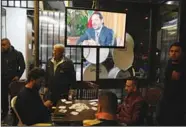  ?? (AP) ?? Lebanese smoke water pipes and play cards at a coffee shop as they listen to outgoing Lebanese Prime Minister Saad Hariri during a live interview shown on his Future TV from Saudi Arabia in Beirut, Lebanon on Nov 12. Hariri said Sunday he will return...