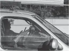  ?? Godofredo A. Vasquez / Staff photograph­er ?? With one hand on the wheel, a motorist uses a cellphone while driving on Loop 610 near the Galleria.