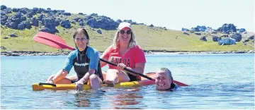  ??  ?? All going swimmingly . . . Natalie Loose (right), formerly of Alexandra, now of Woodend, is accompanie­d by Tricia Connolly (left) and Caitlin Loose, both of Woodend, as she returns from a swim across the reservoir.