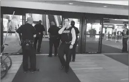  ?? ASSOCIATED PRESS ?? POLICE OFFICERS GATHER AT A TERMINAL at Bishop Internatio­nal Airport Wednesday morning in Flint, Mich.