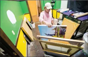  ?? ?? David Faulk, director of the Mardi Gras Museum of Imperial Calcasieu, packs up paintings and other wall hangings from the museum Oct. 12 to be moved to storage while the Central School Arts and Humanities Center undergoes repairs to damage following Hurricane Laura.