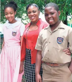  ??  ?? The acting principal and grade-six teacher at Iona Preparator­y in Tower Isle, St Mary, Sophia Ormsby, with the school’s top-performing GSAT students for 2017, deputy head girl Jade Lawrence and head boy Kirk Boswell.