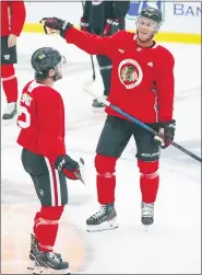  ?? KAMIL KRZACZYNSK­I — THE ASSOCIATED PRESS ?? Chicago Blackhawks’ Jonathan Toews, right, talks to teammate Alex Debrincat, a Farmington Hills native, during Monday’s first day of camp at Fifth Third Arena in Chicago.