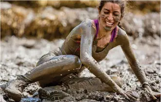  ??  ?? Gruelling test: A woman takes a tumble on the Tough Mudder course