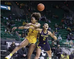  ?? Rod Aydelotte/ Waco TribuneHer­ald via AP ?? ■ Baylor guard DiDi Richards, left, blocks the shot of West Virginia guard Kysre Gondrezick, right, in the first half of an NCAA basketball game Monday in Waco, Texas.