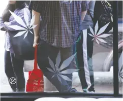  ?? Pat rick T. Falon / Bloombe rg Files ?? Marijuana leaves are displayed on a window outside a cannabis dispensary in West Hollywood, Calif. The U.S. chill towards the cannabis industry is starting to thaw.