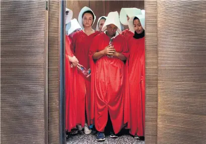  ?? JIM WATSON AFP/GETTY IMAGES ?? Protesters dressed as characters from the TV series The Handmaid's Tale arrive in an elevator at the Senate Office Building.