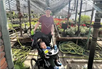  ?? PHOTO PROVIDED ?? Joel Young and son, Lincoln, in a favorite place for Joel, amid flowers, plants, etc.