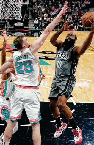  ?? Eric Gay / Associated Press ?? The Nets’ James Harden, driving inside on the Spurs’ Jakob Poeltl, recorded a triple-double with 37 points, 10 rebounds and 11 assists during Brooklyn’s victory Friday night at the AT&T Center.