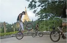 ??  ?? Young bikers performing stunts in a park in Yangon.