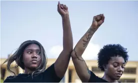  ?? Photograph: Lynda M Gonzalez/AP ?? Tyra Wilson and Kita Williams participat­e in an 8-minute and 46-second kneel in honor of George Floyd during a demonstrat­ion at Dallas City Hall on 4 June.