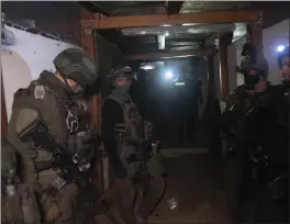  ?? SAM MCNEIL — THE ASSOCIATED PRESS ?? Israeli soldiers stand in a Hamas tunnel underneath a cemetery during a ground offensive on the Gaza Strip in Khan Younis on Saturday.