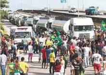  ?? AP ?? Demonstrat­ors briefly stop empty fuel trucks arriving to ■ refill at a fuel distributi­on facility, as they protest the rise in fuel costs in Duque Caxias, Brazil, on Monday.