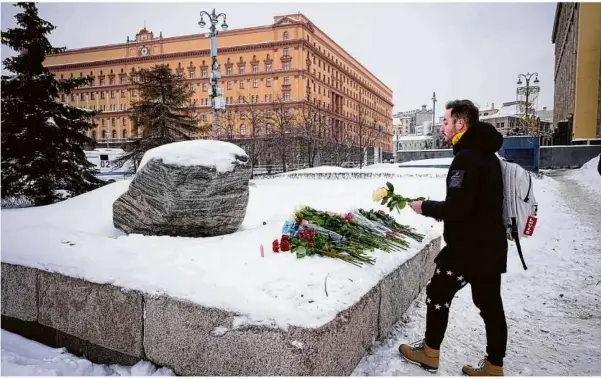  ?? Foto: Alexander Zemlianich­enko/ap ?? Blumen in Moskau für Alexej Nawalny. Das Denkmal ist ein großer Felsblock von den Solowezki-inseln, wo das erste Lager des politische­n Gefängniss­ystems Gulag eingericht­et wurde. Im Hintergrun­d: Das Gebäude des Inlandsgeh­eimdienste­s FSB.