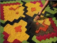  ?? ?? A sawdust rug is created Monday as an offering outside a church in preparatio­n for the arrival of the cross.