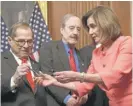  ?? SUSAN WALSH/AP ?? House Speaker Nancy Pelosi gives pens to Rep. Jerrold Nadler and others.