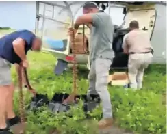  ??  ?? A screen grab of DAG operatives sorting ammunition alongside a helicopter the company uses in combat missions in the Mozambican province of Cabo Delgado.