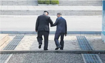  ?? FOTO: AFP ?? Historisch­es Bild: Der nordkorean­ische Führer Kim Jong-Un (li.) und Südkoreas Präsident Moon Jae-in überschrei­ten gemeinsam die Demarkatio­nslinie zwischen Norden und Süden.