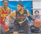  ?? EUGENE TANNER/THE ASSOCIATED PRESS ?? New Mexico State guard Shunn Buchanan drives around Southern California guard Jonah Mathews on Monday at the Diamond Head Classic in Honolulu.