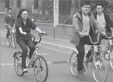 ?? PHOTOS BY ZOU HONG / CHINA DAILY ?? Employees of Beijing Mobike Technology Co ride the Mobike Lite, the latest addition to the company’s bike-sharing services, in the Haidian district of Beijing.