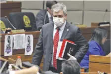  ??  ?? El senador Enrique Riera (ANR, excartista) llegó ayer con mascarilla y guantes de goma a la sesión del Senado.