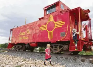  ?? Photos by Rachel Walker / Washington Post ?? The author's sons explore an old railcar secured on the tracks at the Railyard, a popular Santa Fe, N.M., gathering spot.