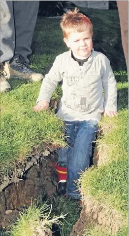  ??  ?? Crevasse: A 10-metre long crack in James and Melanie Taylor’s back garden has undermined the stability of their house, and is big enough for their 3-year-old son Jesse to stand in.