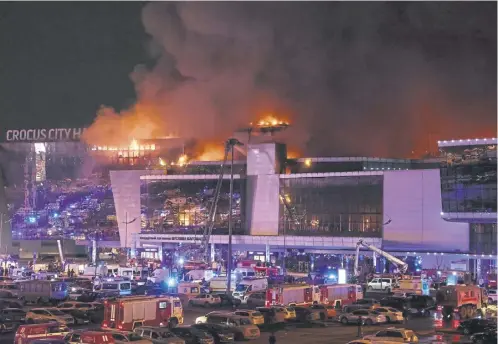  ?? ?? Emergency services vehicles are seen outside the burning Crocus City Hall concert hall following the shooting