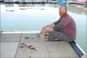  ?? Bennett Horne/The Weekly Vista ?? Marina and Trails Manager Trey Anson works on putting a dock at Lakepoint Marina on Loch Lomond back together after the recent draw down on the lake. The marina opened for the new season on Friday, April 1.