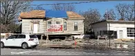  ?? Arkansas Democrat-Gazette/ERIC E. HARRISON ?? The house behind the former service station at Kavanaugh Boulevard and Beechwood Street is being moved rather than demolished as part of a plan to convert the property into a burger restaurant with green space.