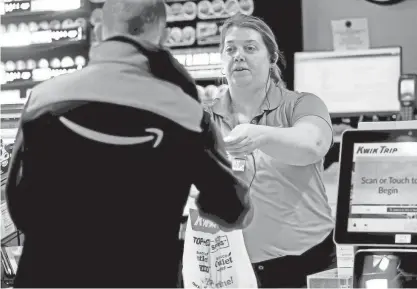  ?? ANGELA PETERSON / MILWAUKEE JOURNAL SENTINEL ?? Lindsey Zettel, assistant store leader, checks out a customers at the Kwik Trip at 2807 River Valley Road in Waukesha last spring.