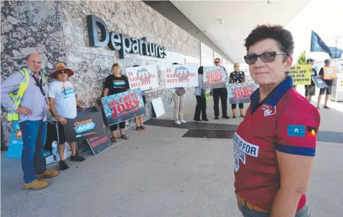  ?? Picture: STEWART McLEAN ?? SEEKING ASSURANCES: Cairns regional organiser for United Voice Trish Berrill with protesters at the airport.