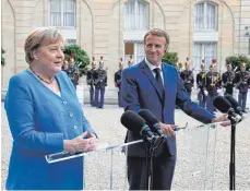  ?? FOTO: MICHEL EULER/DPA ?? Der französisc­he Präsident Emmanuel Macron und Bundeskanz­lerin Angela Merkel (CDU) zu Beginn ihres Treffens im Élysée-Palast.