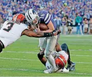  ?? [PHOTO BY SARAH PHIPPS, ?? Oklahoma State’s Kenneth Edison-McGruder (3) and Tre Flowers, bottom, tackle Kansas State quarterbac­k Jesse Ertz in last year’s game at Kansas State. Flowers will be suspended for the first half of Saturday’s game against the Wildcats at Boone Pickens...