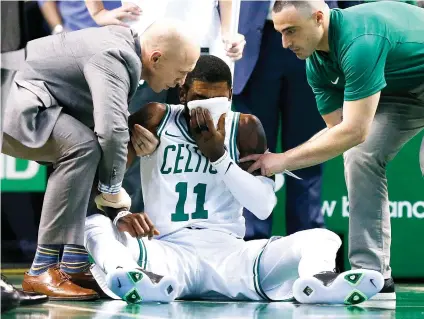  ?? AP FOTO/MICHAEL DWYER ?? ANOTHER
INJURY. Team personnel assist Boston Celtics’ Kyrie Irving (11) after he was injured during the first quarter against the Charlotte Hornets in Boston. Irving took an elbow to the face and left the game.